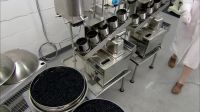 Workers empty the containers into large colanders