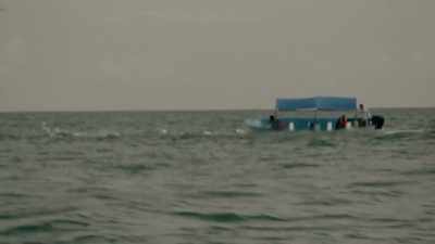 A row of large plastic barrels
floating towards - Trafficked with Mariana van Zeller