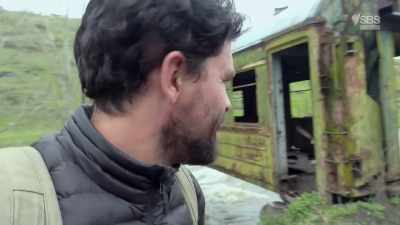 A train carriage has found its way
across a bridge. - From Russia to Iran: Crossing Wild Frontier
