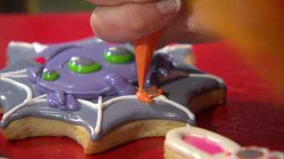 Adding this tiny little
trick or treat basket
to the spider. - Halloween Cookie Challenge