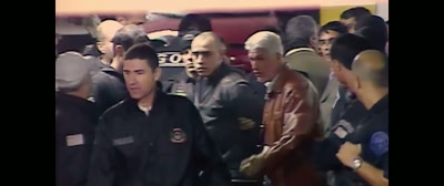 Alexandre Nardoni
is being placed in a police car. - A Life Too Short: The Isabella Nardoni Case