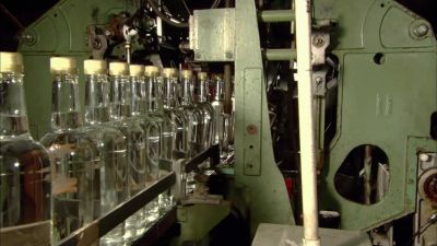At the next station,
robotic arms grab labels, - How It's Made