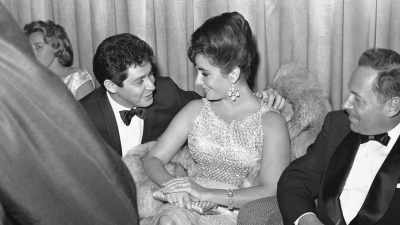 By talking about him. - Elizabeth Taylor: The Lost Tapes