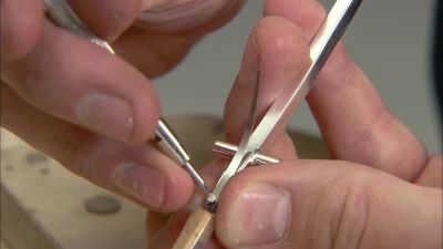 HE THEN FASTENS
FLAT SPRINGS TO SOME KEYS - How It's Made