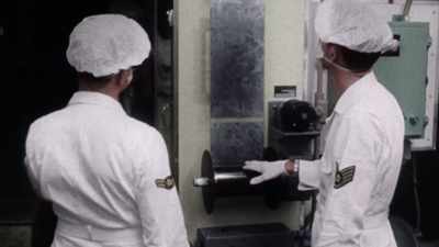 INTELLIGENCE OFFICERS PORE
OVER THEM, LOOKING FOR WEAPONS. - America in Color