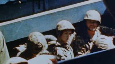 Marines feel relatively
safe huddled in their boats. - The Pacific War in Color