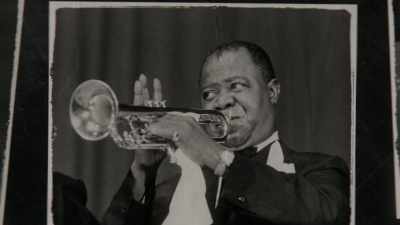 Mopping his brow, ducking his head,
doing his thing for the white man. - Louis Armstrong's Black & Blues