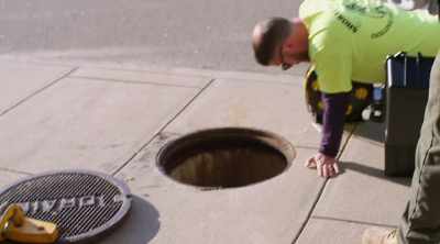 [narrator]  Finding a clog
beneath the parking garage - Sewer Divers