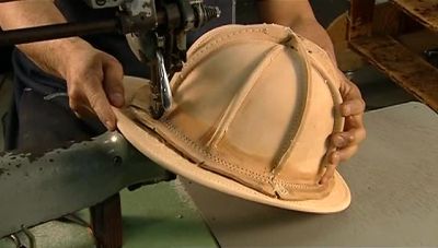 NEXT, A WORKER SEWS THE SKULL
TO THE BRIM. - How It's Made