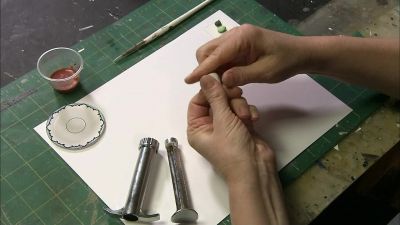 NEXT, SHE WORKS A LUMP
OF POLYMER CLAY - How It's Made