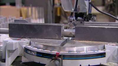 THE BAT IS LOCKED
INTO A HOLDING DEVICE, - How It's Made
