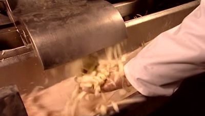 THE FRESHLY CUT POTATO PIECES
DROP INTO A CANAL. - How It's Made