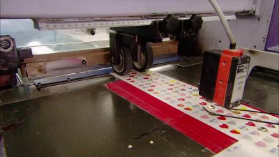 THE NEXT MACHINE
CUTS THE STICKERS INTO SHEETS. - How It's Made