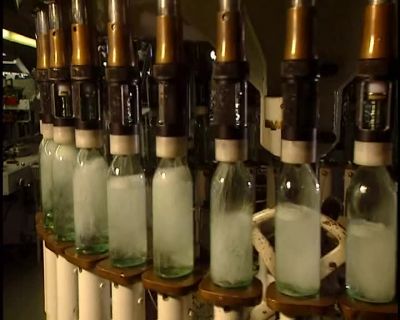 THE NEXT STEP, A CAPPER
PLACES CAPS ON THE BOTTLES - How It's Made