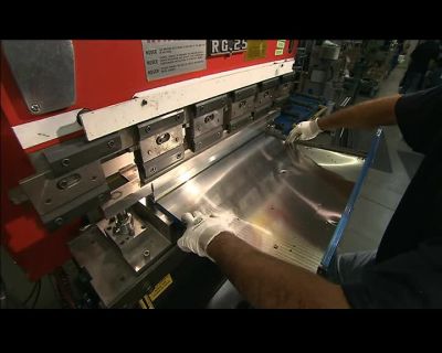 THIS 80-TON PRESS
BENDS THE HOOD'S SHELL, - How It's Made