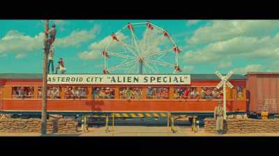 WOMAN OVER SPEAKER:
Extra! Extra! Late edition! - Asteroid City