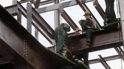 WORKERS FLING RED-HOT RIVETS
BY HAND THROUGH THE AIR. - America in Color
