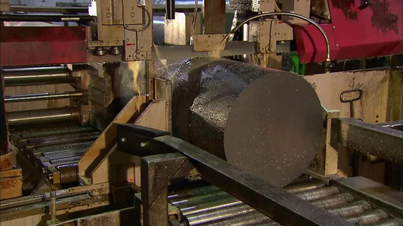 A BAND SAW CUTS THE COOLED INGOTS