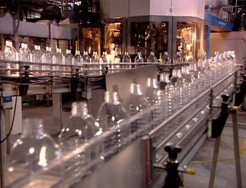 A CONVEYOR BELT TRANSPORTS THE FINISHED BOTTLES