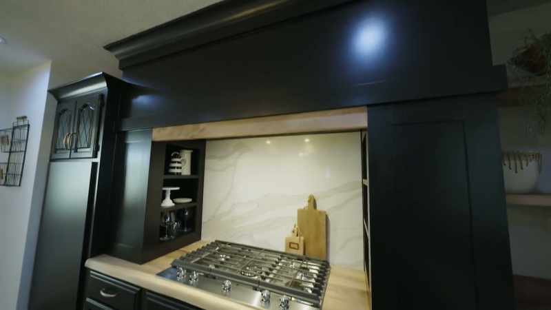 A counter-to-ceiling vent hood with some shelving nooks