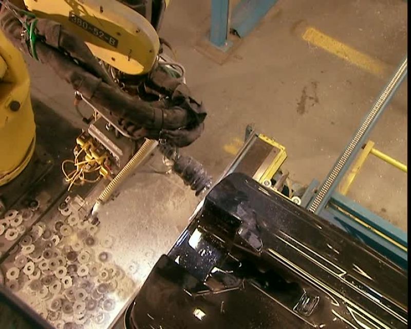 A ROBOT DRILLS HOLES IN THE LOWER SHELL