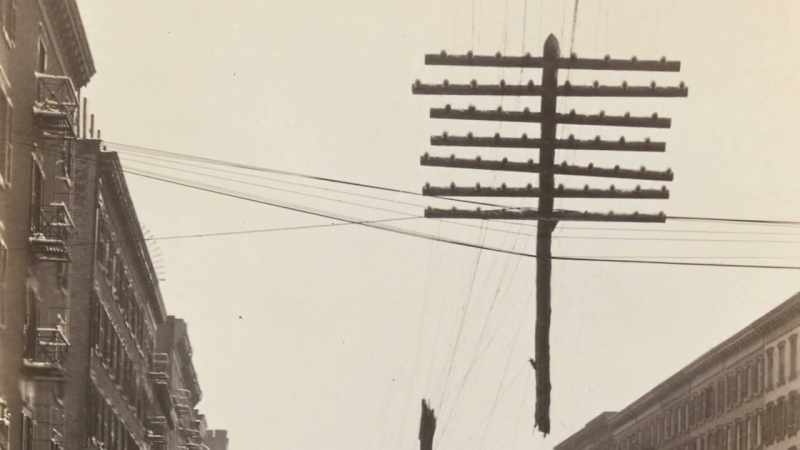 A telegraph pole ripped in half, left dangling over the street