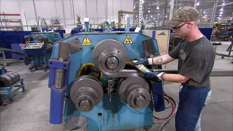 A WORKER CLEANS THE STEEL TUBES, THEN RUNS THEM