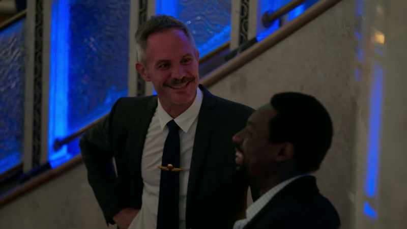 {\an8}Table 2, his pilot wings are on his tie