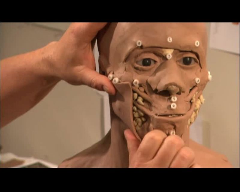 AS HE APPLIES THIS LAYER OF CLAY