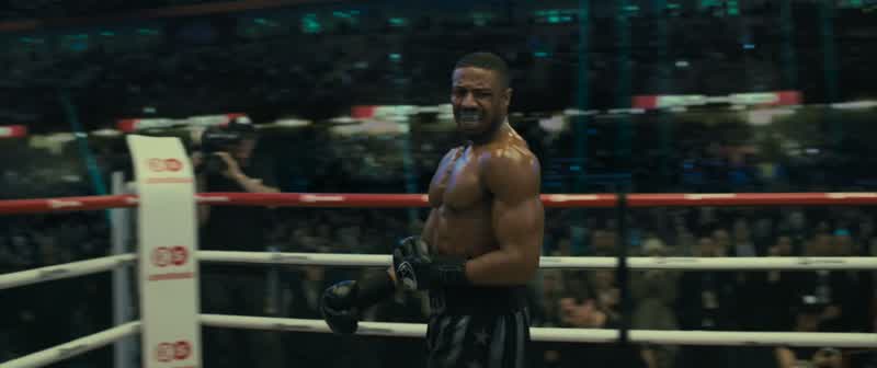 Creed doubled over in pain as Drago tries to pick himself up off the floor