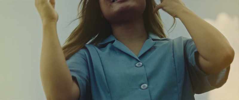 Hand on the seat, maid uniform still on. Smiling