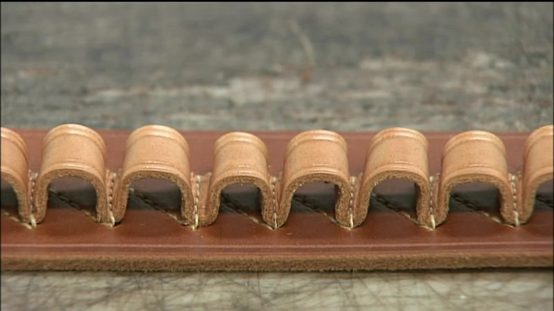 HE GLUES ON A LEATHER LINING TO MAKE THE BELT MORE DURABLE