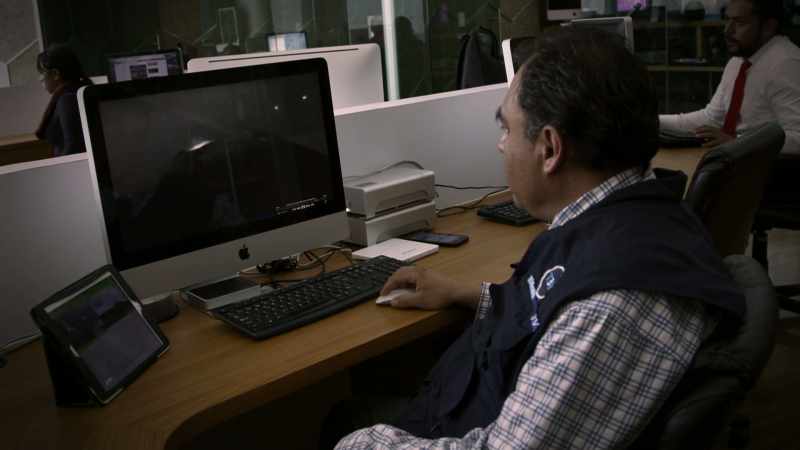 HE SEARCHES THE SURVEILLANCE FOOTAGE, FRAME BY FRAME