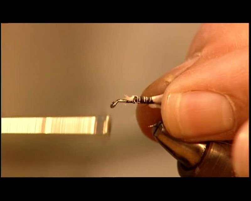 HE SECURES IT ALONG THE MIDDLE OF THE HOOK