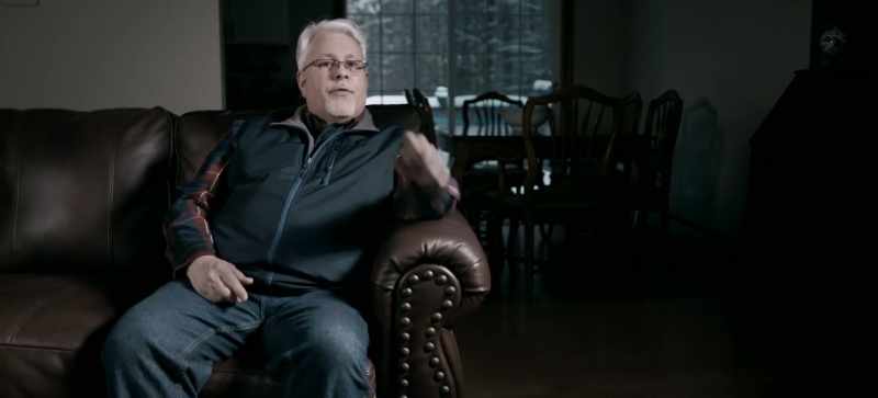 He was sitting at a table, he was sitting back at a table like this