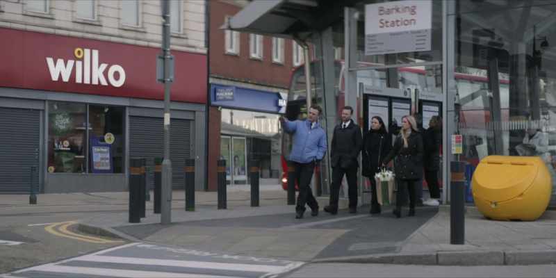 He walks across the road and has a brief conversation with a man