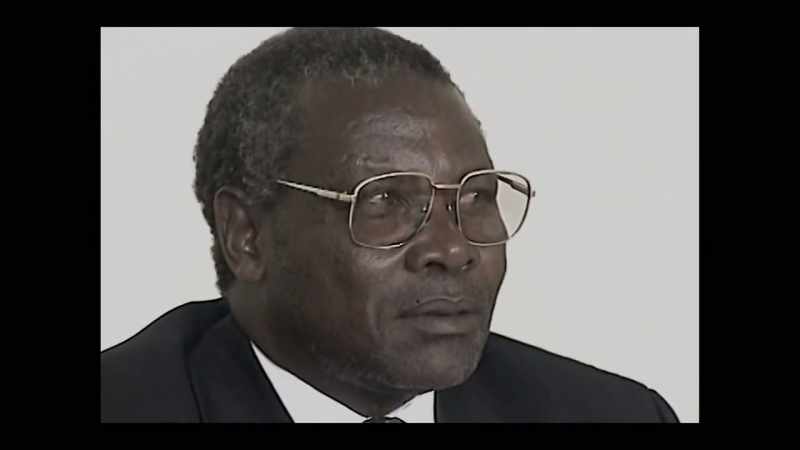 [Kabuga speaks indistinctly in the background]