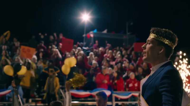 (Loud cheering, marching band plays)