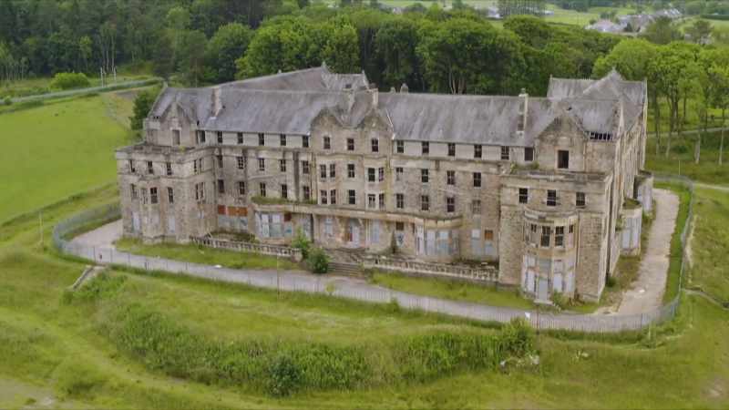 [narrator] Overlooking the newly completed asylum