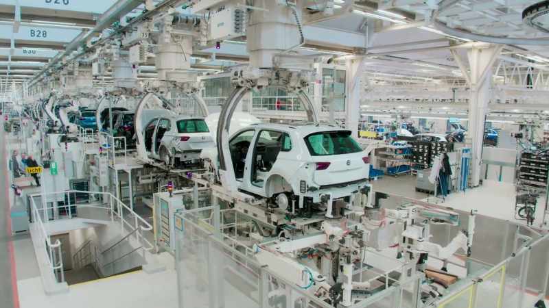 NARRATOR: Together, robots and humans fix chassis to bodies