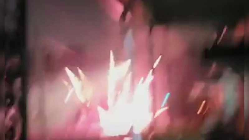 One tries to douse the flames with water from a cooler