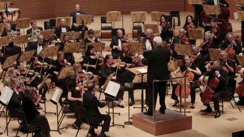 [orchestra playing classical music]