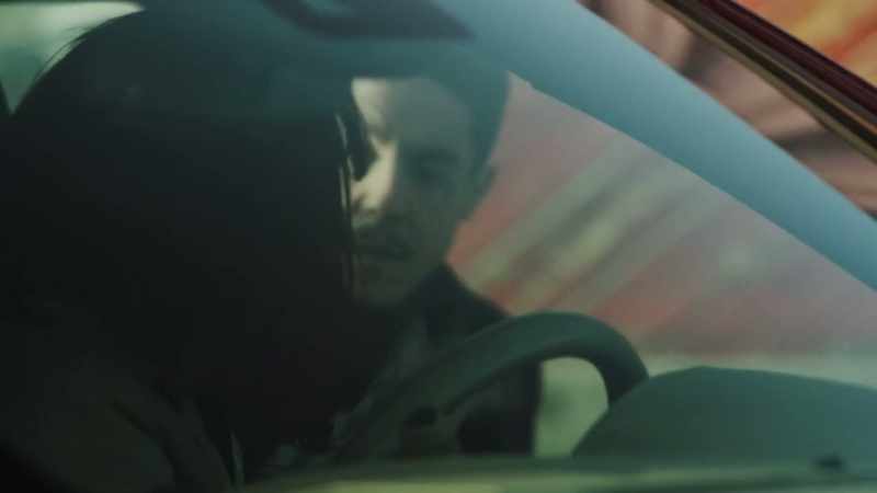 [rock music plays over car speakers]