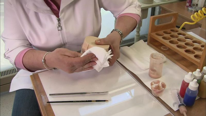 SHE WIPES AWAY ANY EXCESS SILICONE