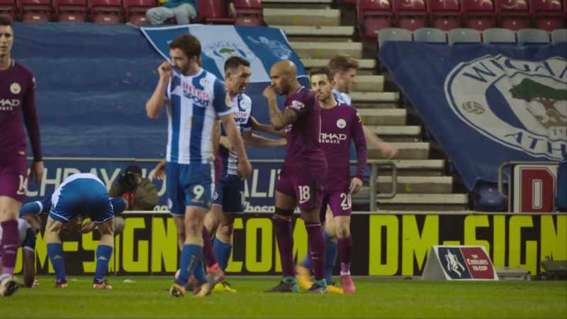 Surrounded by Wigan players the referee