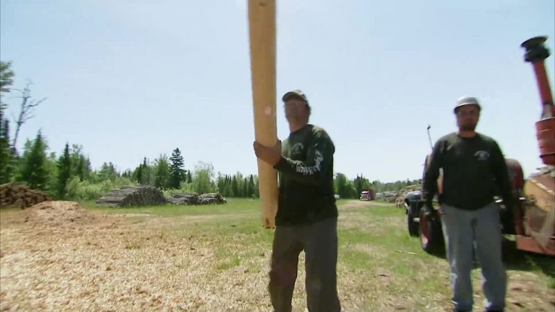 THE DE-BARKING CREW PEELS ABOUT 350 LOGS A DAY