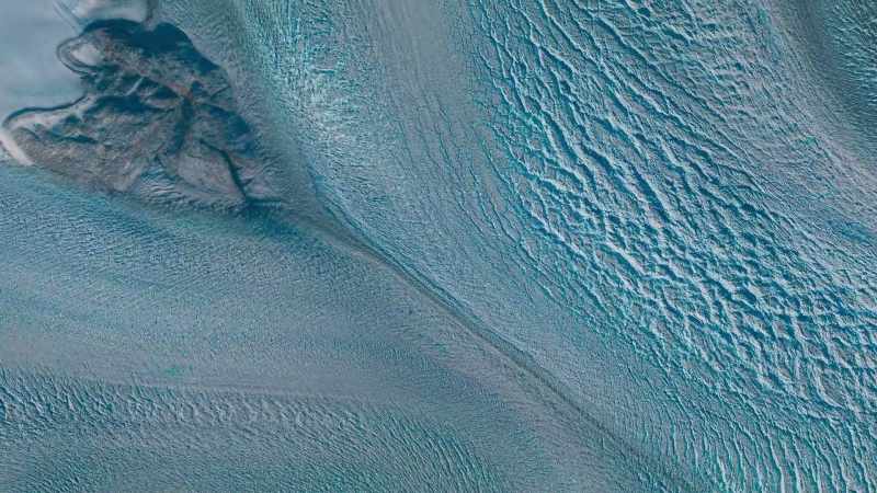 The increased meltwater accelerates the ice sheet's slide downhill