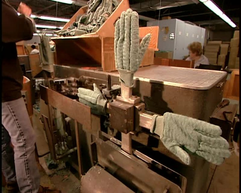 THE MACHINE THEN PRESSES EACH GLOVE ONTO THE FORM