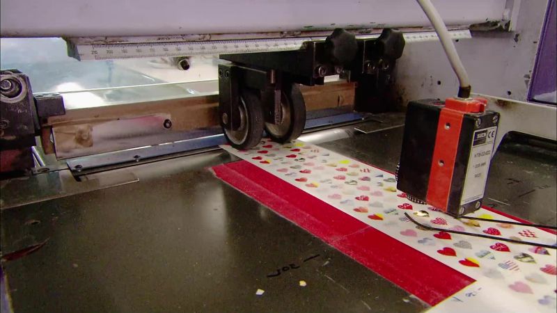 THE NEXT MACHINE CUTS THE STICKERS INTO SHEETS