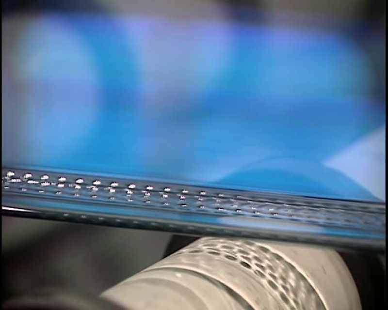 THE RIBBON OF GLASS ROLLS GENTLY ON ROLLERS